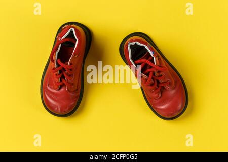 Kinderschuhe in rot auf gelbem Hintergrund. Warme Schuhe. Stockfoto