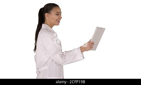 Junge Ärztin hält Tablet in den Händen und macht einen Videoanruf auf weißem Hintergrund. Stockfoto