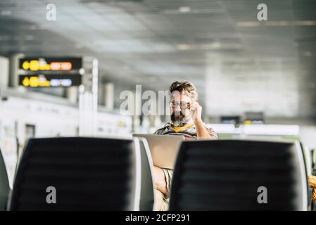 Erwachsene kaukasischen Mann arbeiten an einem Laptop-Computer wartet seine Flug am Flugsteig - Konzept des digitalen Nomaden Und Technologie Job bezogen - moderne pe Stockfoto