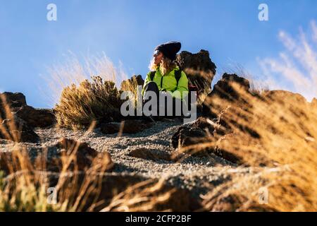 Frau entspannt sitzen auf dem Boden nach einem Trekking Ausflug - Konzept der Reise und Outdoor-Freizeit Sport Wanderung Aktivität mit kaukasischen Menschen enj Stockfoto