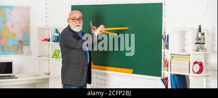 Wiederholen Sie nach mir. In Richtung Wissen. Studieren Sie Mathematik, um gute Ergebnisse zu erhalten. Senior man Lehrer verwenden Kompass-Werkzeug. Bärtige Tutor Mann zeichnen mit Kompass auf Tafel. Zurück zur Schule. Mathematische Grafik-Tools Konzept. Stockfoto