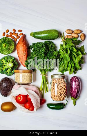 Gesunde Ernährung flach legen. Frisches Gemüse, Obst, Nüsse, Quinoa, Kichererbsen auf weißem Hintergrund. Zero Waste, veganes Essen, umweltfreundliches Konzept. Stockfoto