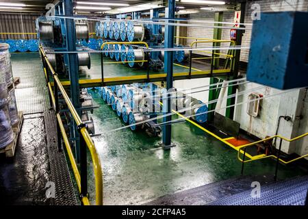 Johannesburg, Südafrika - 16. Oktober 2012: Weitwinkelansicht von Kabelspulen auf einer großen Maschine in einer Förderbandfabrik Stockfoto