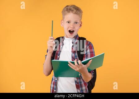 Teenager Junge hält Notebook und heben Stift im Studio Stockfoto