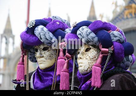 VENEDIG, ITALIEN - 16. FEBRUAR 2015:zwei Masken in Turbanen am Markusplatz (Markusbasilika im Hintergrund) während des traditionellen Karnevals. Karneval i Stockfoto