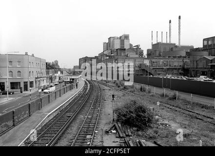 Die jetzt geschlossene Silvertown Station, die auf der North Woolwich Branch der ehemaligen North London Line war. Bis 1990 war die North London Line auf eine einzige Strecke reduziert worden. Die up-Linie wurde als reine Frachtverbindung zu dem, was lokal als Silvertown Tramway bekannt war, beibehalten. Die Straßenbahn folgte der Route der ursprünglichen Nord Woolwich Linie. In seiner Blütezeit strahlte ein Labyrinth von Linien von dieser Route ab, die eine Güterverkehrsader durch das Royal Victoria Dock im Hafen von London und die Thames Wharf-Gegend bildete. Es war mit der Nord-Woolwich-Niederlassung südlich des Bahnhofs Canning Town am Kreuzpunkt Thames Wharf verbunden Stockfoto