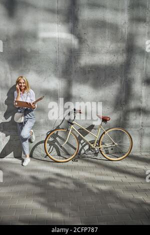 Business Dame in eleganten Freizeitkleidung mit Gespräch mit ihr Kunde auf dem Smartphone Stockfoto