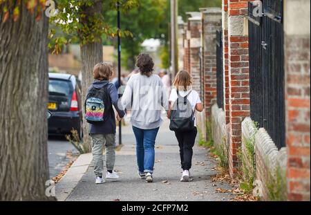 Brighton UK 7. September 2020 - Rachael Holdsworth mit den Töchtern Romy (10) auf der linken Seite und Bodil (8) als Schüler und Eltern kommen zurück in St. Luke's Primary School in Brighton heute Morgen, wo die Straße gesperrt wurde, um bei der sozialen Distanzierung und Verkehrssicherheit bei ihrer Rückkehr zu helfen Bildung . Die neue Schule Street Scheme wurde eingeführt, um vierzehn Schulen durch den stadtrat für den Beginn der Amtszeit im September und wird zweimal am Tag für eine Stunde zwischen 8-10.00 und 2-4 Uhr durchgesetzt : Credit Simon Dack / Alamy Live News Stockfoto