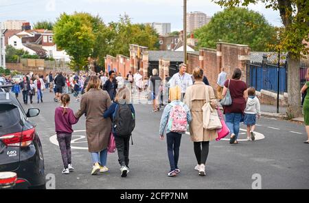 Brighton UK 7. September 2020 - Schüler, Mitarbeiter und Eltern außerhalb der St. Luke's Primary School in Brighton heute Morgen, wo die Straße gesperrt wurde, um bei der sozialen Distanzierung und Verkehrssicherheit bei ihrer Rückkehr zur Bildung zu helfen. Das neue Schulstraßenschema wurde von der stadtverwaltung für den Beginn der Amtszeit im September an vierzehn Schulen eingeführt und wird zweimal täglich für eine Stunde zwischen 8-2-4 Uhr und 22 Uhr durchgesetzt : Credit Simon Dack / Alamy Live News Stockfoto