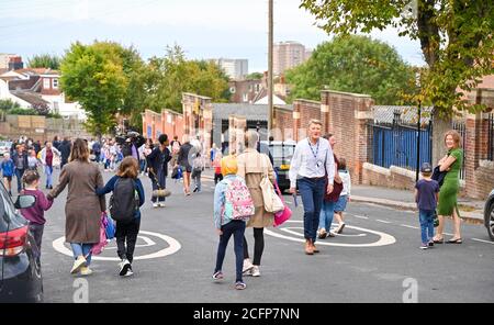 Brighton UK 7. September 2020 - Schüler, Mitarbeiter und Eltern außerhalb der St. Luke's Primary School in Brighton heute Morgen, wo die Straße gesperrt wurde, um bei der sozialen Distanzierung und Verkehrssicherheit bei ihrer Rückkehr zur Bildung zu helfen. Das neue Schulstraßenschema wurde von der stadtverwaltung für den Beginn der Amtszeit im September an vierzehn Schulen eingeführt und wird zweimal täglich für eine Stunde zwischen 8-2-4 Uhr und 22 Uhr durchgesetzt : Credit Simon Dack / Alamy Live News Stockfoto