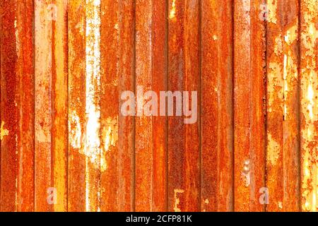 Alte rostige Tür eines verlassenen Zauns aus korrodiertem verzinktem Material. Helle abstrakte Textur mit hoher Auflösung Stockfoto