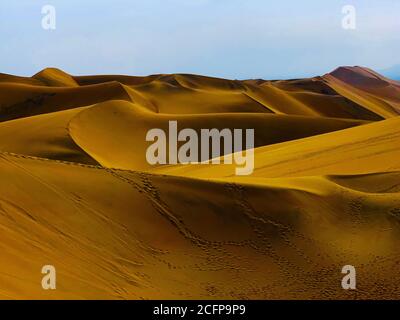 Gelbe Sanddünen in trockener Wüste in der Nähe von Oasis Huacachina, Peru. Orangefarbene sandige Wellen. Beeindruckende Wüstenlandschaft. Landschaftlich trockene Wildnis.schöne barkhan Stockfoto