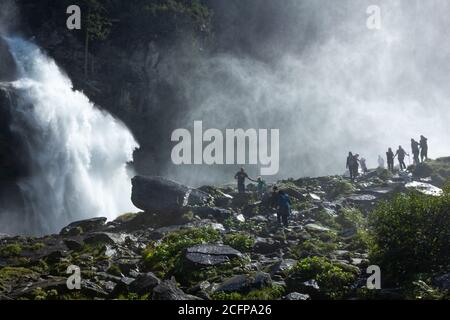 Mehrere Touristen wandern im Nebel des Krimmler Wasserfalls (Krimml, Salzburger Land, Österreich) Stockfoto