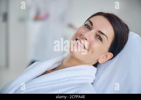 Fröhliche Frau in einem Bademantel in einem Schönheitssalon Stockfoto