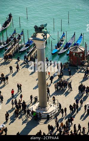 VENEDIG, ITALIEN - 16. FEBRUAR 2015: Touristenmassen unter dem Denkmal des geflügelten Löwen in der Nähe des Dogenpalastes am Markusplatz während des Karnevals in Venedig Stockfoto