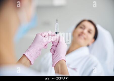 Doktor, der vor ihrer lächelnden Patientin steht Stockfoto