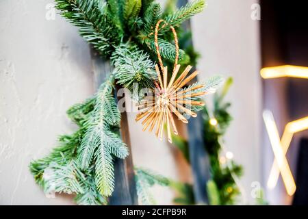 Ein Weihnachtsspielzeug in Form eines Sterns hängt am Baum. Handgefertigt Stockfoto