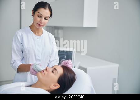 Dunkelhaarige Frau, die sich einer Hautverjüngung unterziehen Stockfoto