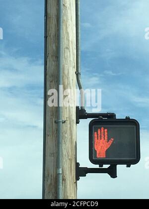 Vertikale Aufnahme des roten Handzeichens „Don't walk“ bei A Fußgängerüberweg Stockfoto
