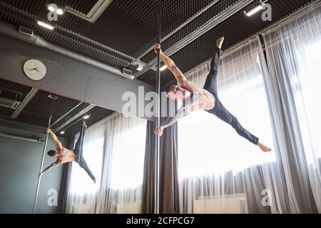 Muskulöser Mann tanzt in einer Klasse mit großem Fenster Stockfoto