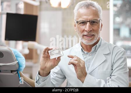 Professionelle zahnärztliche Experte hält ein Gipsmodell der Kiefer Stockfoto