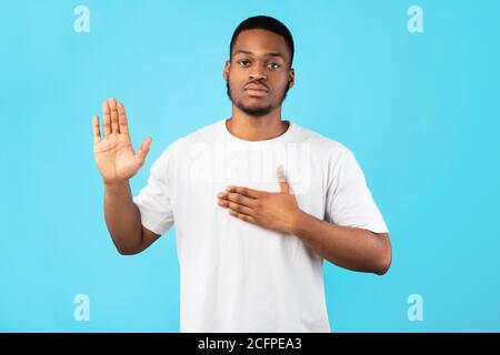 Ehrlicher Afroamerikanischer Mann, Der Schwöre Geste Über Blauem Hintergrund Stockfoto