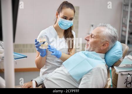 Qualifizierte weibliche Zahnmediziner hält Zahnimplantate Stockfoto