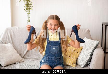 Kleines Mädchen hält Paar High Heels Schuhe Stockfoto