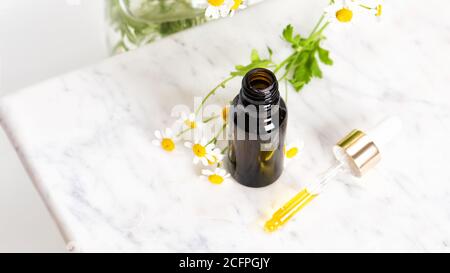 Glasflasche braun Essenz oder Serum und mit Kamille Blumen Stockfoto