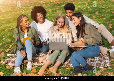 Internationale fröhliche Studenten studieren im öffentlichen Park Stockfoto