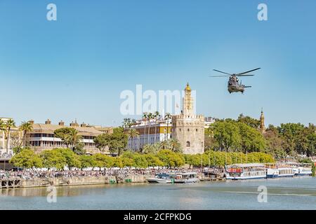 Sevilla, Spanien - 31. Mai 2019: Militärhubschrauber fliegt über den Guadalquivir Fluss während des spanischen Armeetag in Sevilla, Spanien Stockfoto