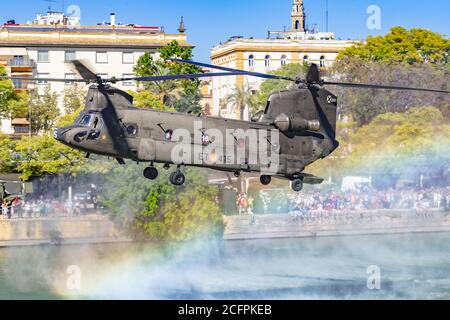 Sevilla, Spanien - 31. Mai 2019: Militärhubschrauber fliegt über den Guadalquivir Fluss während des spanischen Armeetag in Sevilla, Spanien Stockfoto