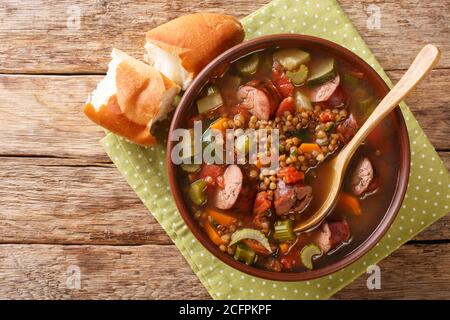 Köstliche heiße Wurst Linsensuppe mit saisonalem Gemüse Nahaufnahme in einem Teller auf dem Tisch. Horizontale Ansicht von oben Stockfoto