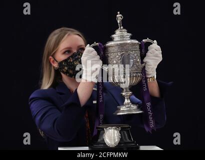 Laurel Kemp aus Bonhams mit der ältesten erhaltenen Trophäe des FA Cup während einer Vorschau auf den Sporting Trophies Sale, der am 29. September als Saleroom in der Bonhams New Bond Street stattfinden wird. Der silberne zweigefertigte Pokal, geschätzt auf GBP 700,000 -900,000, wurde von Vaughton und Sons of Birmingham im Jahr 1896 gemacht und wurde den FA Cup-Siegerteams zwischen 1896 und 1910, darunter Manchester United, Manchester City, Everton, Newcastle United und Tottenham Hotspur übergeben. Stockfoto