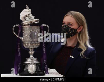 Laurel Kemp aus Bonhams mit der ältesten erhaltenen Trophäe des FA Cup während einer Vorschau auf den Sporting Trophies Sale, der am 29. September als Saleroom in der Bonhams New Bond Street stattfinden wird. Der silberne zweigefertigte Pokal, geschätzt auf GBP 700,000 -900,000, wurde von Vaughton und Sons of Birmingham im Jahr 1896 gemacht und wurde den FA Cup-Siegerteams zwischen 1896 und 1910, darunter Manchester United, Manchester City, Everton, Newcastle United und Tottenham Hotspur übergeben. Stockfoto