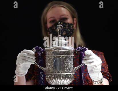 Laurel Kemp aus Bonhams mit der ältesten erhaltenen Trophäe des FA Cup während einer Vorschau auf den Sporting Trophies Sale, der am 29. September als Saleroom in der Bonhams New Bond Street stattfinden wird. Der silberne zweigefertigte Pokal, geschätzt auf GBP 700,000 -900,000, wurde von Vaughton und Sons of Birmingham im Jahr 1896 gemacht und wurde den FA Cup-Siegerteams zwischen 1896 und 1910, darunter Manchester United, Manchester City, Everton, Newcastle United und Tottenham Hotspur übergeben. Stockfoto