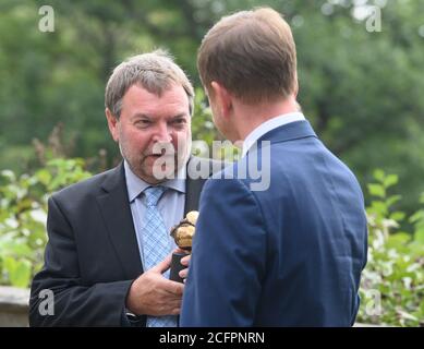 06. September 2020, Sachsen, Dresden: Seerretter Claus-Peter Reisch (l.) spricht mit dem sächsischen Ministerpräsidenten Michael Kretschmer (CDU) nach der Verleihung des 24. Erich Kästner-Preises des Dresdner Presseclubs mit dem Preis in den Händen im Garten von Schloss Albrechtsberg. Im Sommer 2018 verbrachte Claus-Peter Reisch Tage im Mittelmeer für den Dresdner Verein Mission Lifeline mit 230 Flüchtlingen, die aus Seenot gerettet wurden und von keinem Staat aufgenommen werden wollten. Der Preis ist mit 10 000 Euro dotiert und wird alle zwei Jahre vergeben. Foto: Robert Michael/dpa-Zent Stockfoto