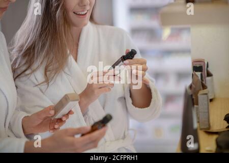 Zwei hübsche Frauen diskutieren Kosmetik im Salon Stockfoto