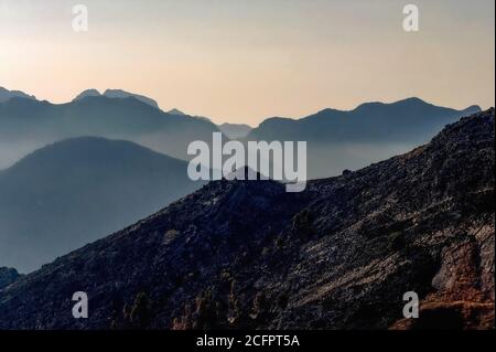 Der nahende Sonnenuntergang zeichnet die zerklüftete Landschaft jenseits des Lago Rosamarina in Sizilien, Italien, mit einem weichen Dunst aus. Stockfoto