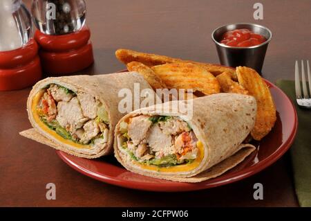 Ein Hähnchenwickel-Sandwich mit panierten Bratkartoffelkeilen Stockfoto