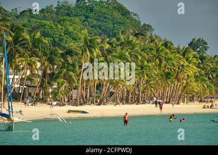 Boracay, Philippinen - 29. Januar 2020: Weißer Strand der Insel Boracay. Touristen gehen am Strand entlang und schwimmen im Meer. Einige Tage vor dem Ausbruch Stockfoto