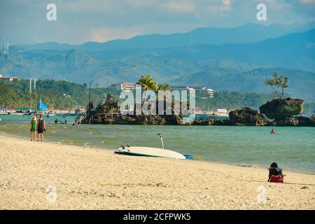 Boracay, Philippinen - 29. Januar 2020: Weißer Strand der Insel Boracay. Touristen gehen am Strand entlang und schwimmen im Meer. Einige Tage vor dem Ausbruch Stockfoto