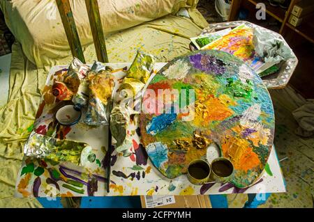 Ein Tisch in einem Atelier mit Ölfarben und einer Palette. Stockfoto