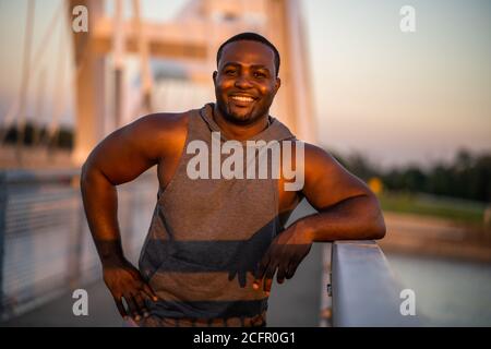 Porträt eines jungen fröhlichen afroamerikanischen Mannes in Sportkleidung, der bereit für die Ausübung ist. Stockfoto
