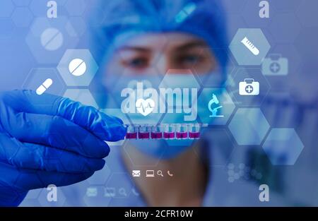 Frau in Maske und Handschuhen, die Materialien zum Testen zeigen Stockfoto