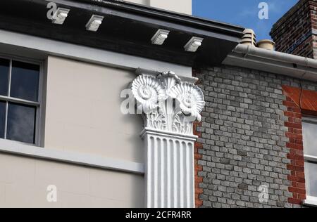 Nahaufnahme von Ammoniten-Hauptstädten auf einem Gebäude (Castle Place), entworfen vom Architekten Amon Wilds, in der Lewes High Street, East Sussex. Stockfoto