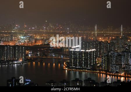 Hong Kong Nacht Stadtbild (Rambler Channel, Tsing Yi und Tsuen Wan) mit Stonecutters Bridge und Hong Kong Island im Hintergrund Stockfoto