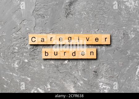 Pfleger Bürde Wort auf Holzblock geschrieben. Caregiver Burden Text auf Zementtabelle für Ihr Design, Konzept. Stockfoto