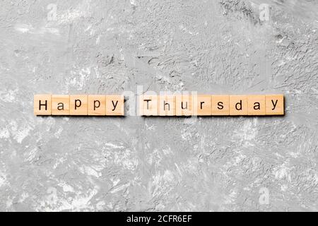 Happy thursday Wort auf Holzblock geschrieben. Happy thursday Text auf Zementtisch für Ihr Design, Konzept. Stockfoto