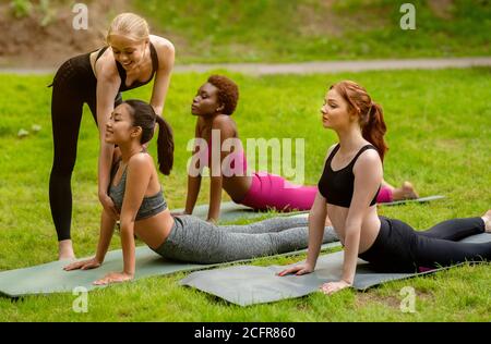 Yogalehrerin mit ihren Schülern während des Outdoor-Trainings im Park Stockfoto